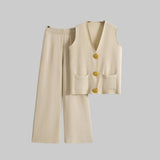 Beige vest and wide-leg pants on hangers against a gray background