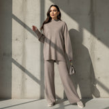 Woman wearing a beige outfit with a matching handbag on a gray background