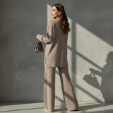 Woman wearing a brown outfit with a matching handbag on a gray background