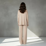 Woman wearing a beige suit on a light gray background