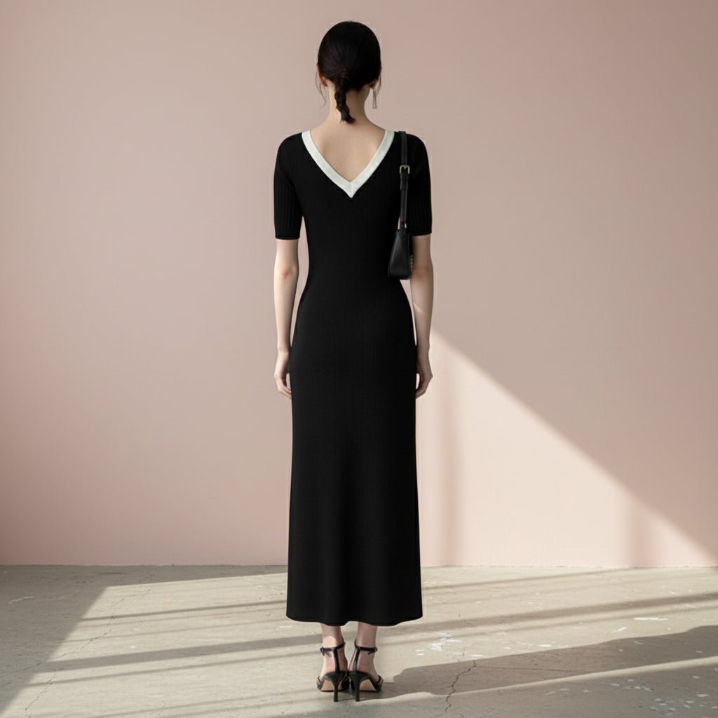 Woman wearing a black dress with a white collar on a gray background