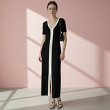 Woman wearing a black and white dress on a gray background