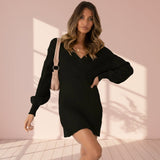 Woman wearing a black ribbed dress with a plain background