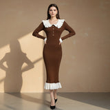 Woman wearing a brown dress with white collar and hem on a gray background